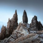 Futuristic landscape with towering rocks, landed spaceship, and hovering spacecraft