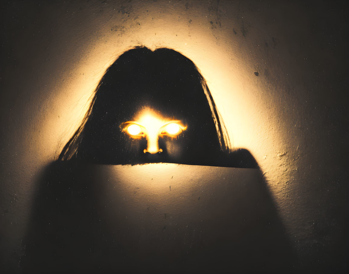 Person's Silhouette with Glowing Eye Light on Textured Wall