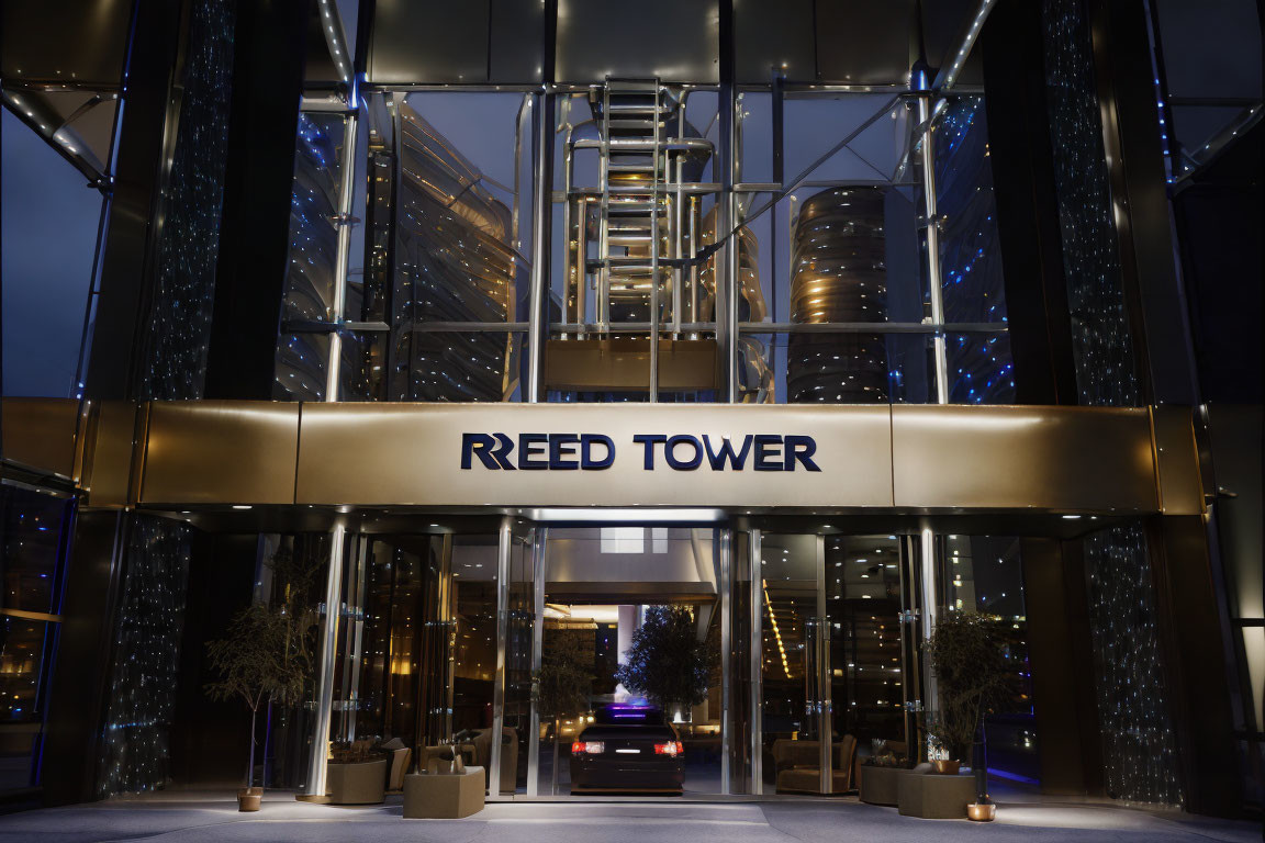 Nighttime view of Reed Tower entrance with glass doors and twinkling lights