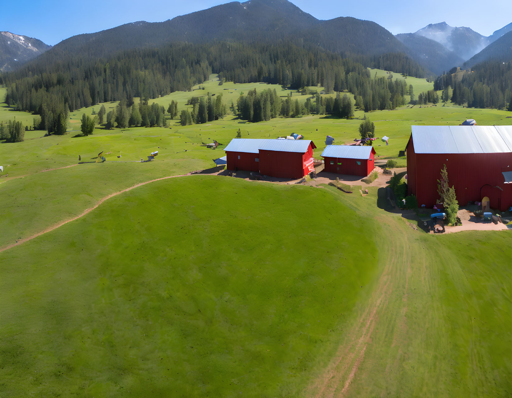 Rural landscape with red farm buildings, green fields, and rolling hills