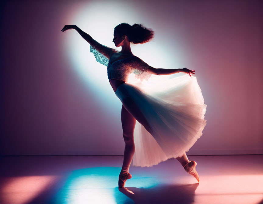 Ballerina silhouette in tutu on toe tips under pink and blue lights