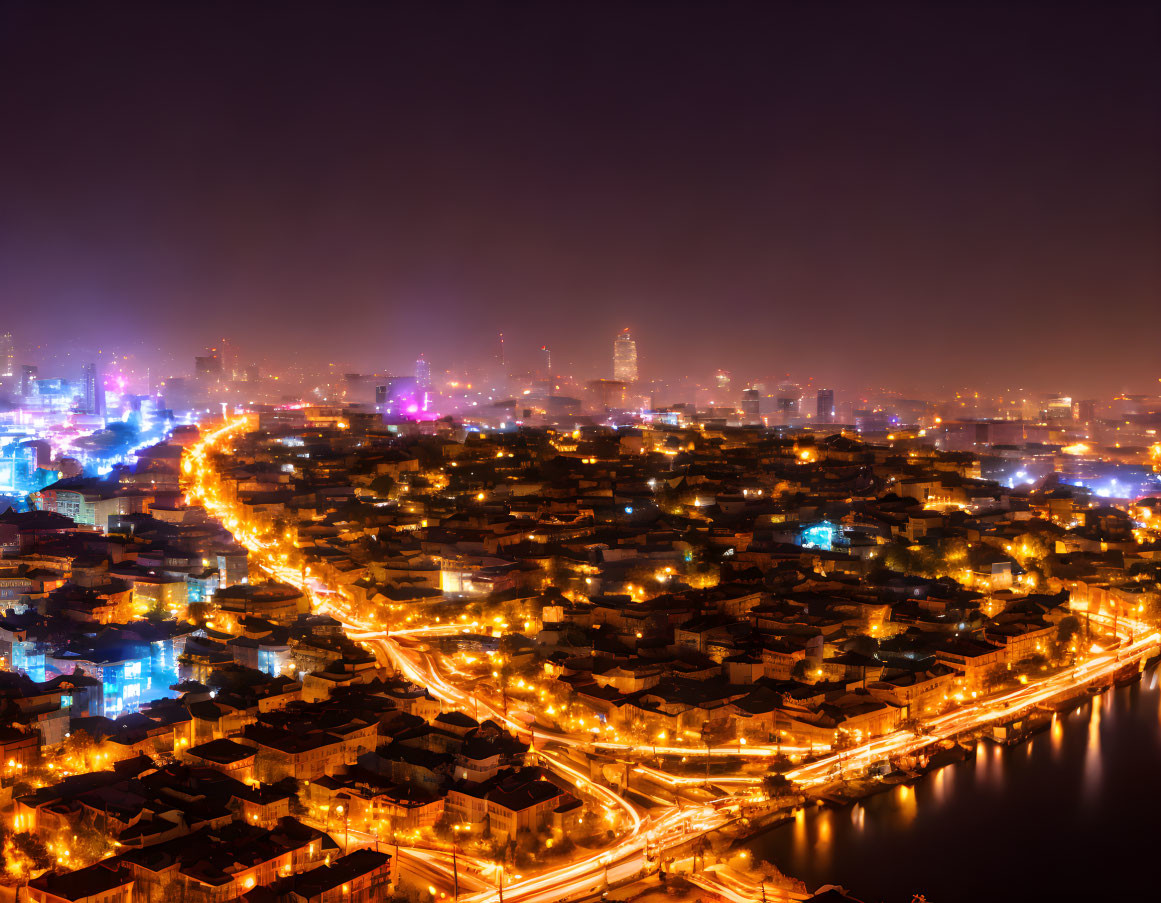 Vibrant nighttime cityscape with glowing lights along a river