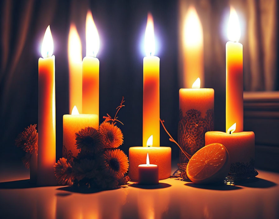 Table with Various Sizes of Lit Candles and Orange Flowers