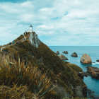 Rugged Cliff with Two Lighthouses and Sailboat on Misty Ocean