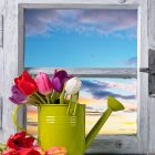 Vibrant flower bouquet in green watering can with butterfly, rustic window frame scenery