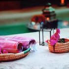 Tranquil spa setting with towels, candles, lanterns, ornate wooden decor, and lush