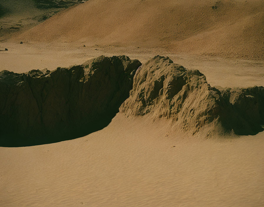 Rocky Outcrop in Sandy Desert Landscape with Hazy Sky