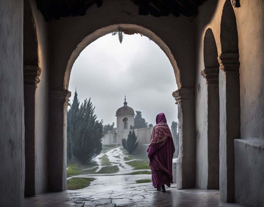 Purple Garment Figure Walking Through Misty Archway in Historical Setting