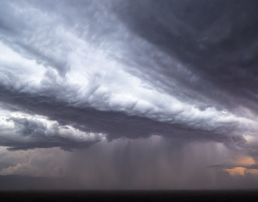 Impressive shelf cloud over plain with pouring rain under stormy sky