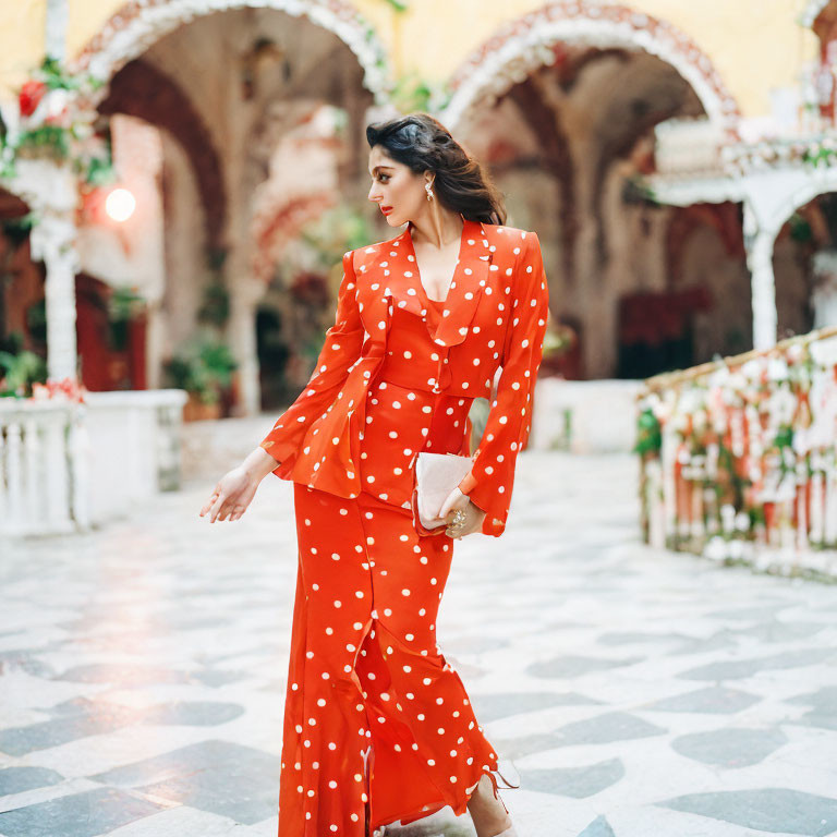 Woman in Red Polka-Dot Dress in Ornate Arcade with Hanging Plants