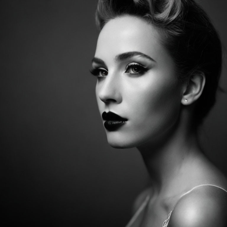 Monochrome portrait of woman with dark lipstick on gray background