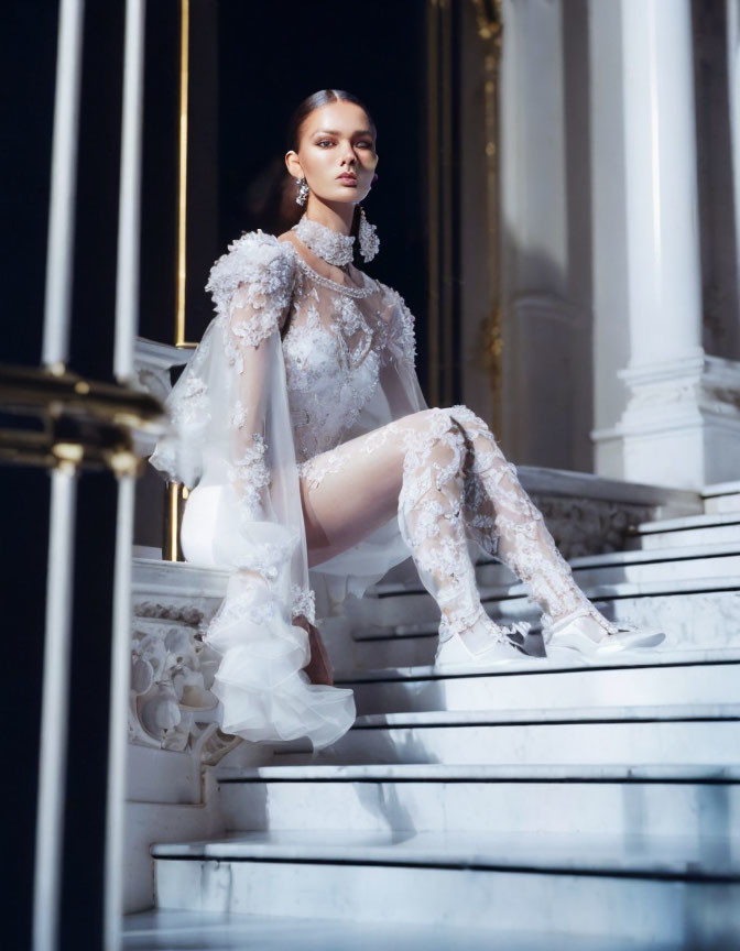 Woman in white lace dress on marble staircase under soft natural light