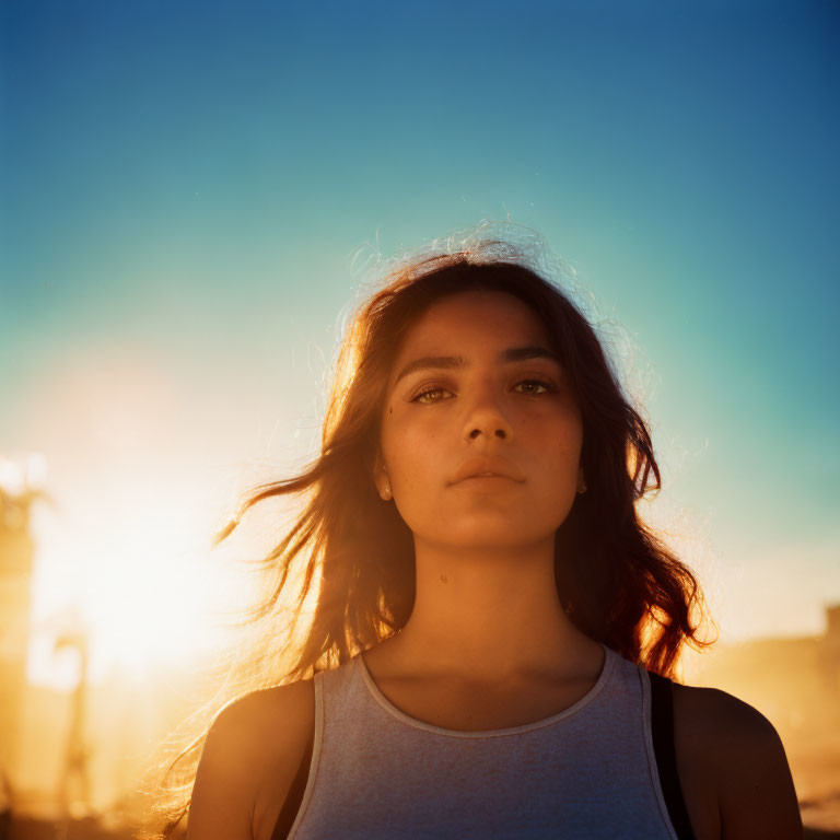 Silhouette of a woman against warm sunset backdrop