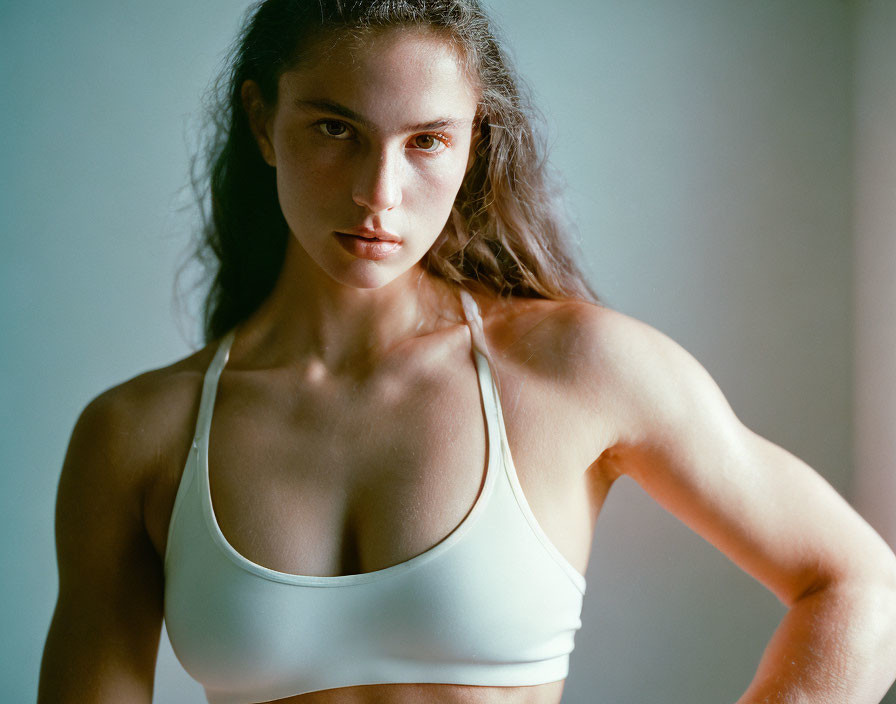 Intense woman in white sports bra exudes confidence and strength
