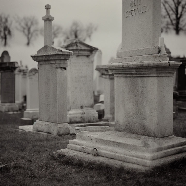 Monochrome photo of aged gravestones in serene cemetery setting