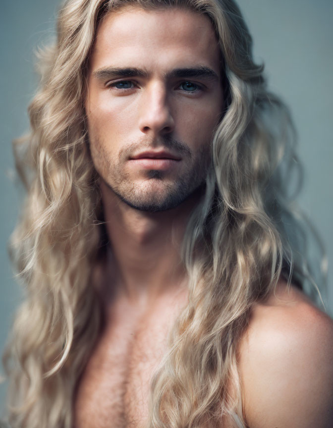 Blonde man with blue eyes and stubble, half-shirtless pose