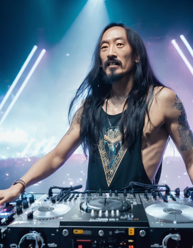 Tattooed DJ with long hair performs under bright stage lights