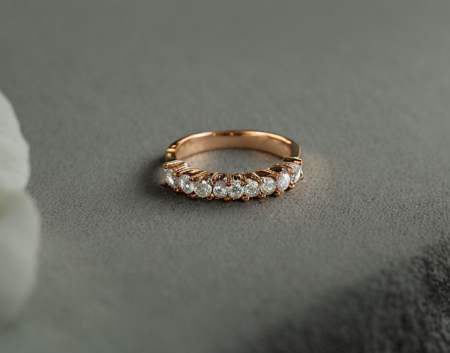 Rose Gold Half-Eternity Ring with Round-Cut Diamonds on Grey Background