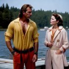 Man and woman in colorful attire standing by riverbank gaze into distance