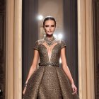 Glittery silver high-low dress on runway with dimly lit audience