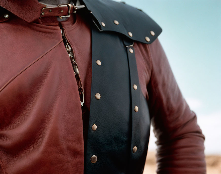 Person in Red Leather Jacket with Blue Metal-Studded Pauldron in Desert