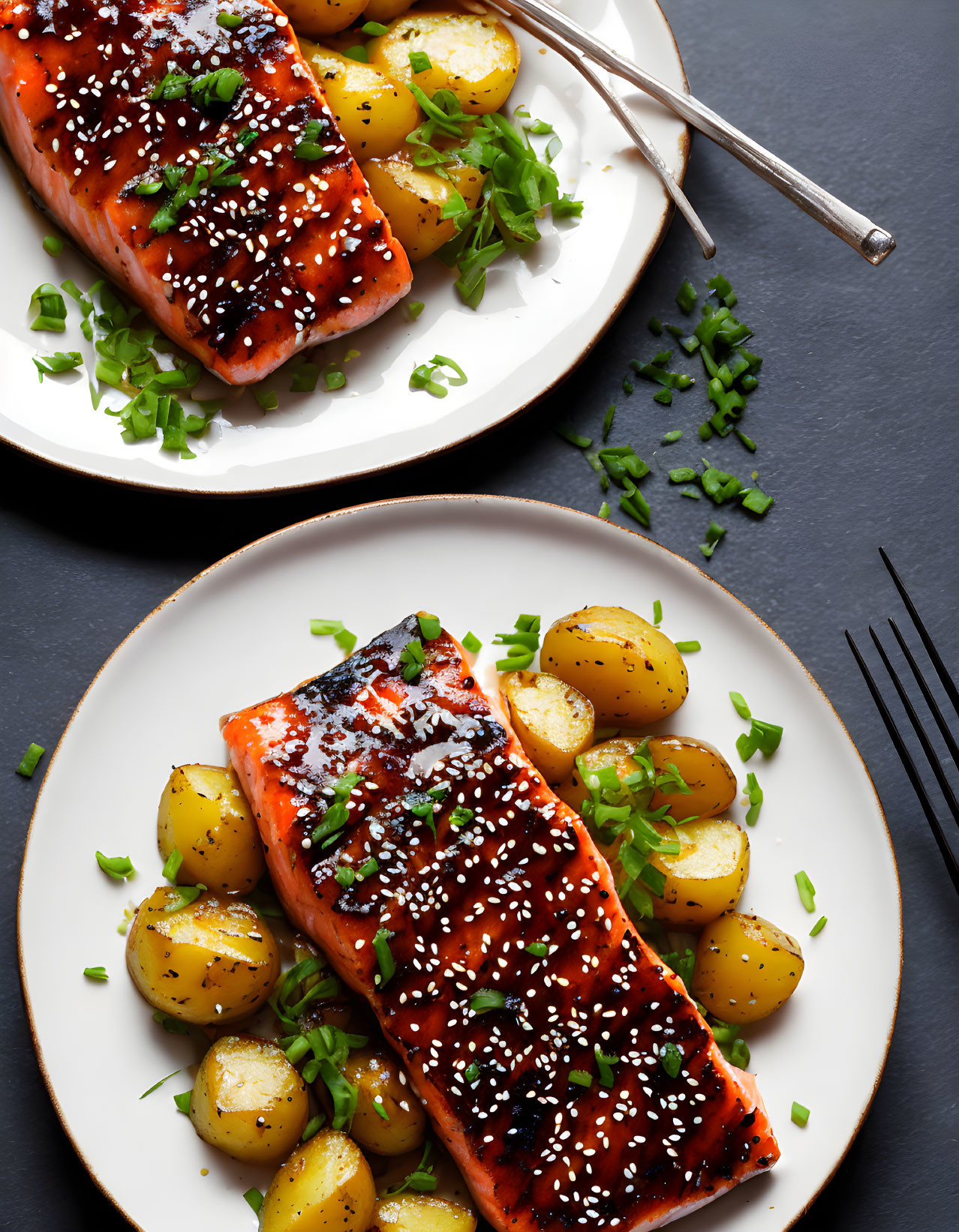 Sesame-Crusted Grilled Salmon with Roasted Potatoes on White Plates