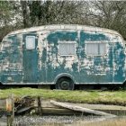 Colorful caravan by forest pond with bicycle