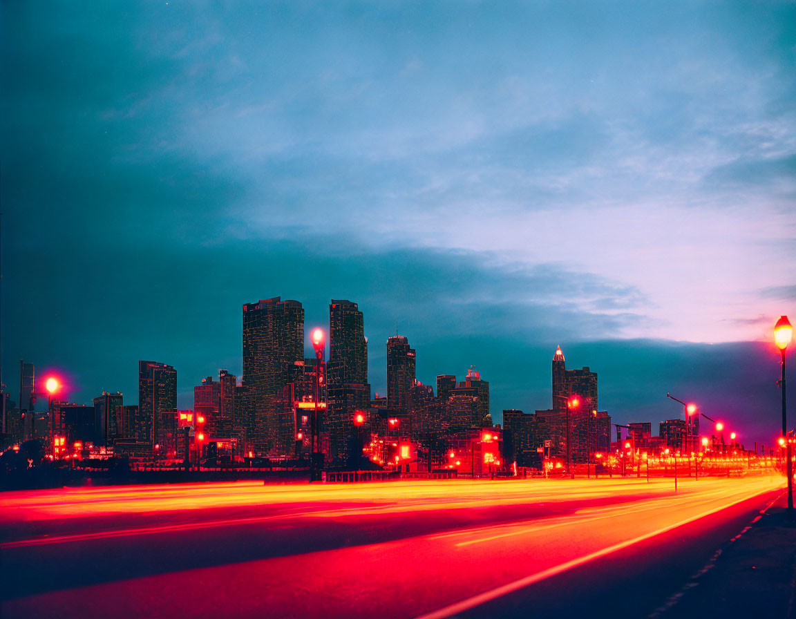 Glowing red street lights in twilight cityscape