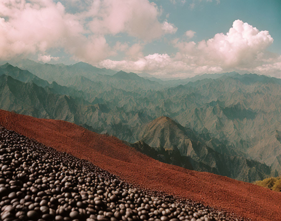 Rugged Mountain Range with Reddish-Brown Rocks and Fluffy Clouds