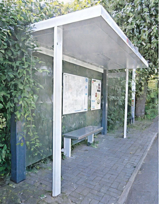 Bus Shelter with Bench, Glass Walls, and Information Boards Covered in Green Foliage