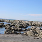 Rocky Shoreline with Boulders in Shimmering Blue Water