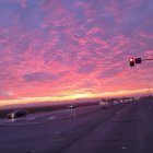 Colorful sunrise over peaceful town with scattered houses.