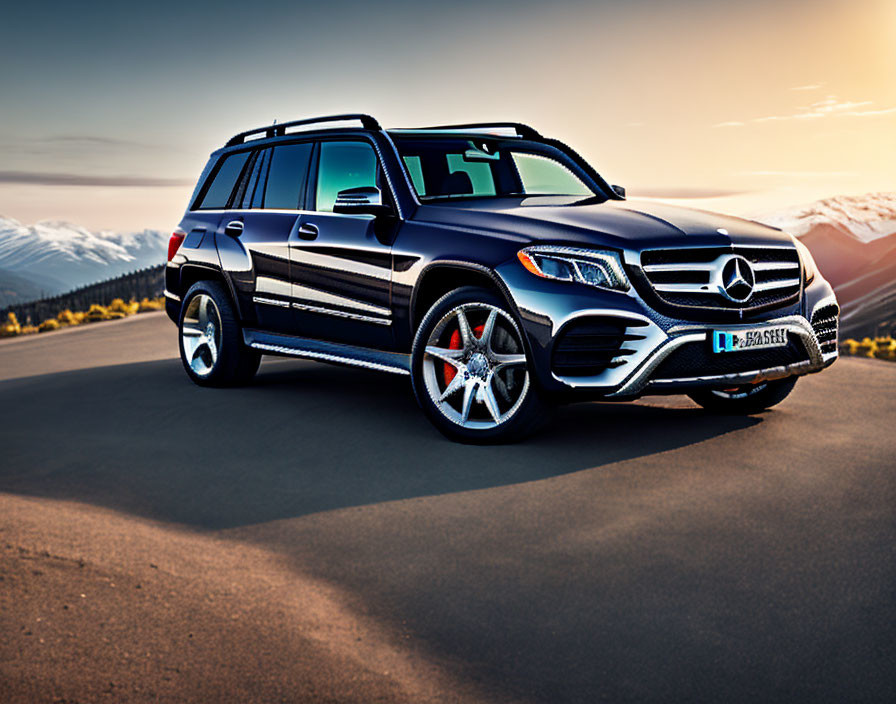 Black Mercedes-Benz SUV parked on mountain road at sunset with snow-capped mountains