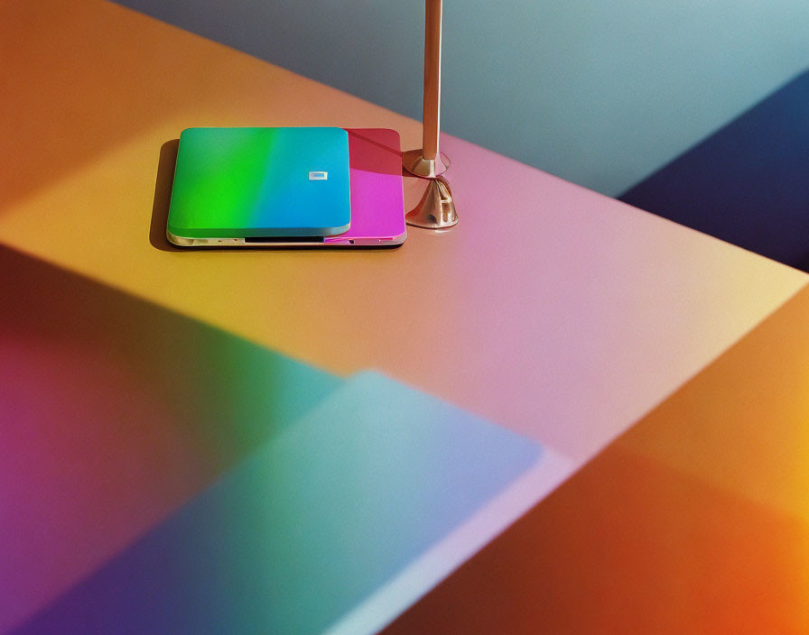 Colorful Laptop with Metallic Finish Next to Modern Lamp