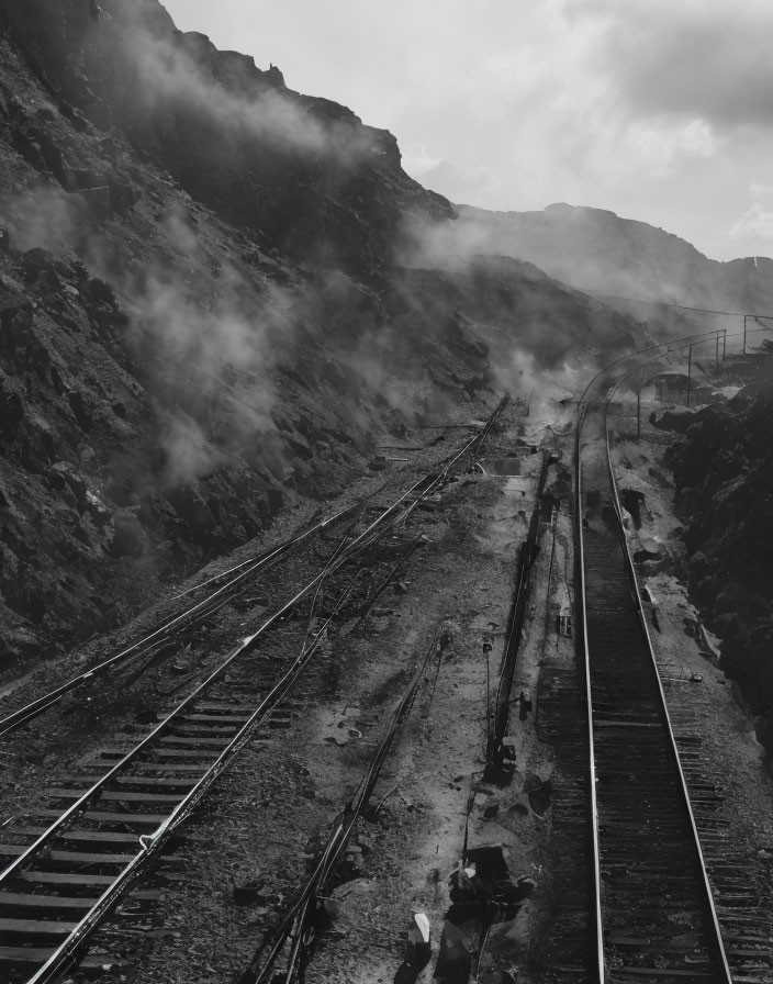 Monochrome image of misty railway in mountainous landscape