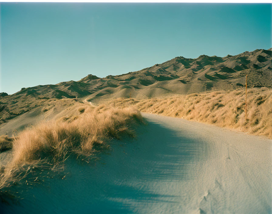 Desert landscape with winding road and sandy hills