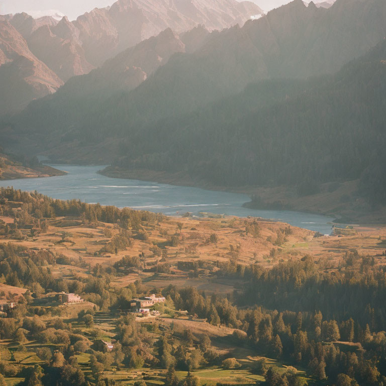 Scenic aerial view of lush valley with river, terraced fields, and mountain ridges