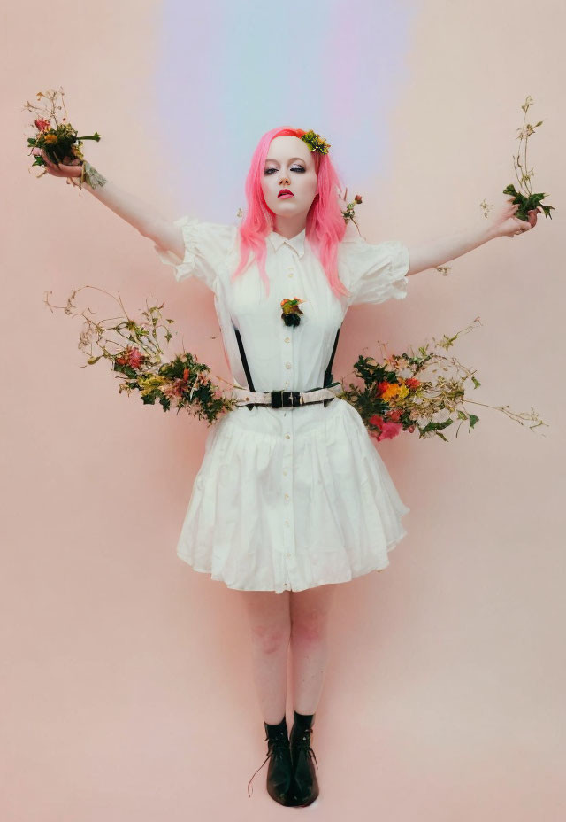 Pink-haired person in white dress with flowers on pink background