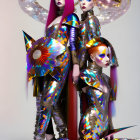 Three futuristic women with vibrant hair and elaborate headgear in metallic costumes next to a sleek white structure