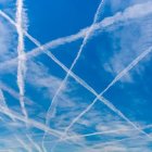 Intersecting Contrails Forming Crisscross Pattern in Blue Sky