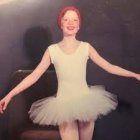 Vibrant image of woman in feathered bodysuit with red hair