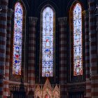 Stained Glass Windows in Dimly Lit Church with Burning Candles