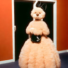 Pink Teddy Bear with Bow and Purse in Doorway with Orange Wall