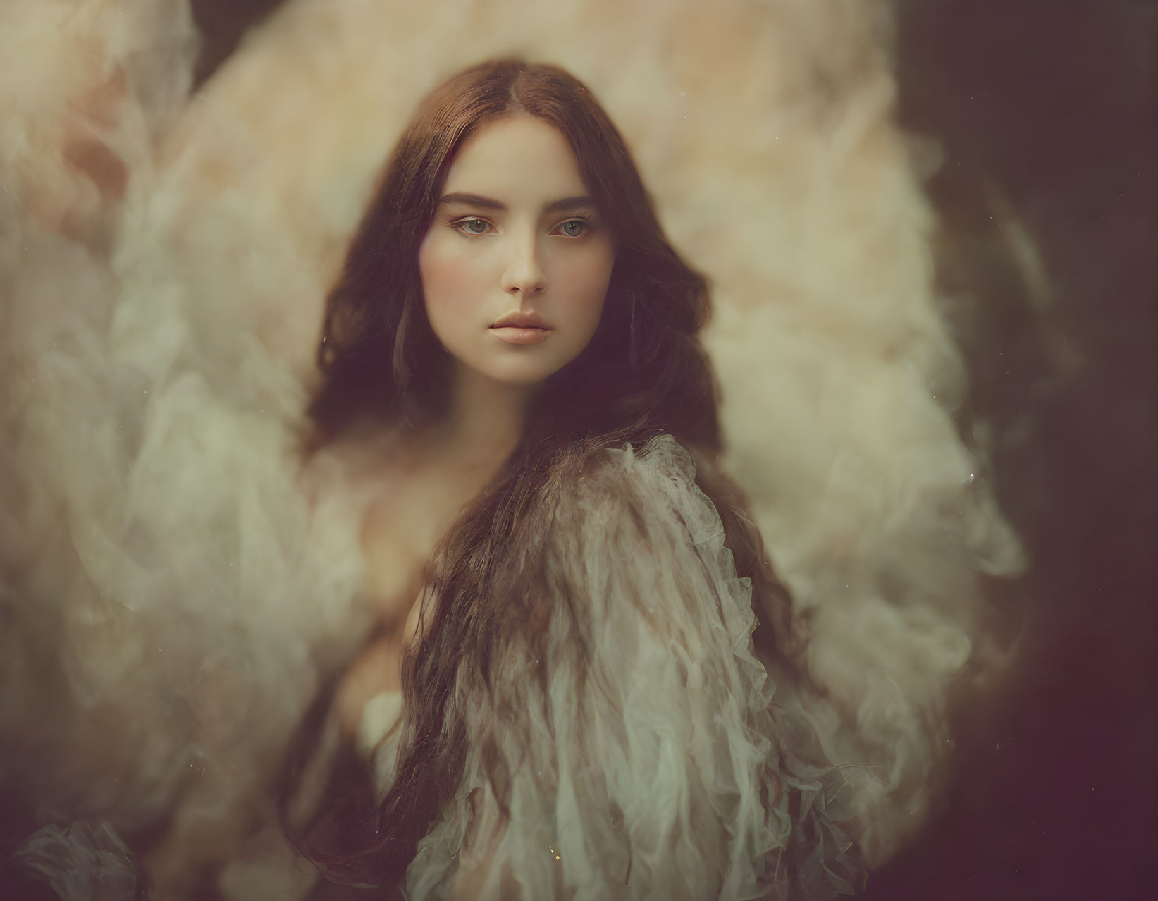 Dark-haired woman draped in textured shawl gazes intently against soft background