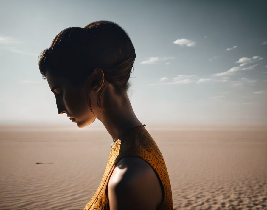 Woman with Hair Up Gazing Down in Desert Sun Glow