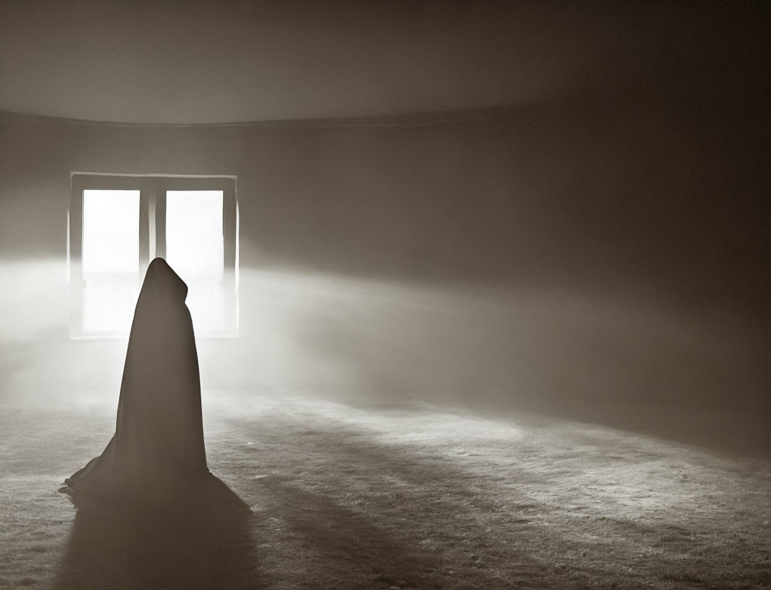 Solitary figure in cloak by open window in dim room