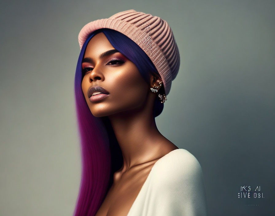 Purple-haired woman in knit cap with subtle makeup on gray background