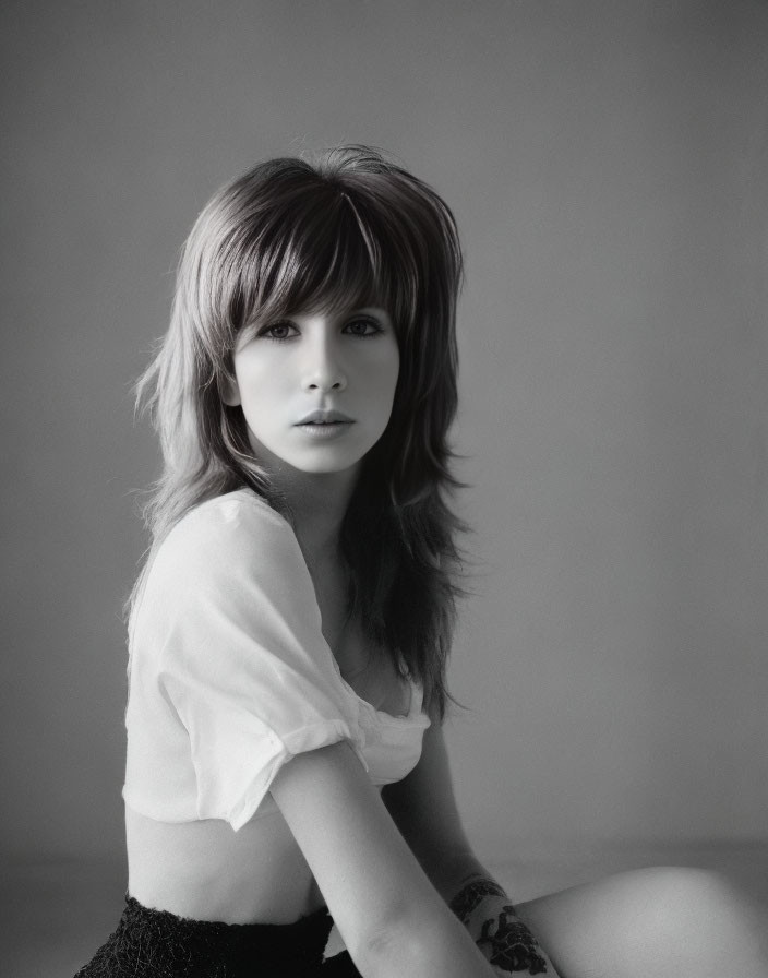 Monochrome portrait of woman with side-swept bangs in blouse and shorts