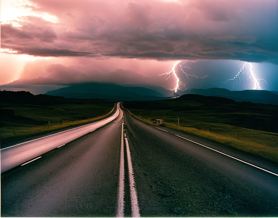 Desolate highway under dramatic stormy sky with lightning.