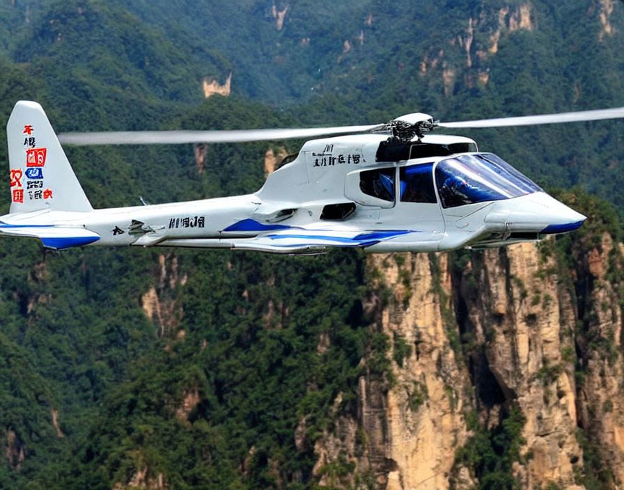 Small white and blue aircraft with Chinese writing flying over lush green mountains